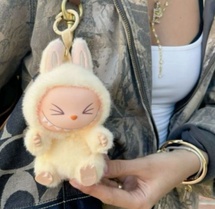 aesthetic grunge girl with fashion accessories has attached a cute labubu doll to her coach purse
